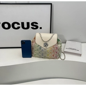 Detail of colorful tweed handbag with white leather flap and elegant flower buckle