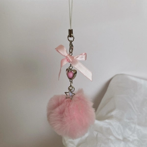 Close-up of pink faux fur ball phone strap with bowknot and heart charms details