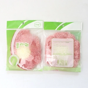 Floral knit dishcloth detail showing pink petals in clear retail packaging with hook