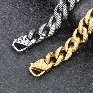 Macro detail of gold and silver textured curb chains with fleur-de-lis engraved clasps