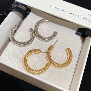 Textured C-shaped stud earrings in gold and silver finish with elegant gift box