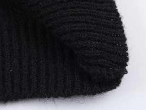 Close-up of black knitted fabric texture showing soft wool fibers and tight weave detail