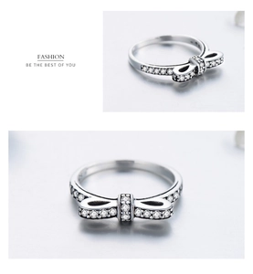 Macro shot of silver bow ring with sparkling zircons and delicate stackable design