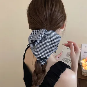 Elegant black and white plaid bow hair scrunchie shown on a model for French style