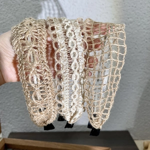Close-up of three woven linen headbands showing intricate braided patterns and texture