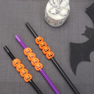 Detail of Halloween straws with orange pumpkin beads on black and purple tubes