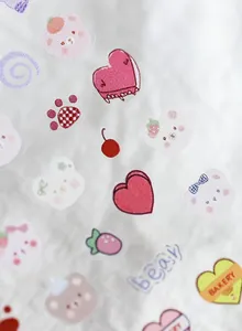 Detail of cartoon bear and strawberry nail stickers with cute pink and red patterns