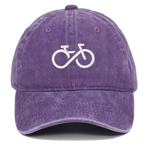 Detailed close-up of bicycle and infinity symbol embroidery on washed cotton baseball cap