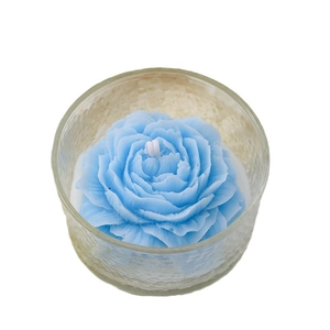 Candela profumata a forma di peonia in una ciotola di vetro martellato su bianco