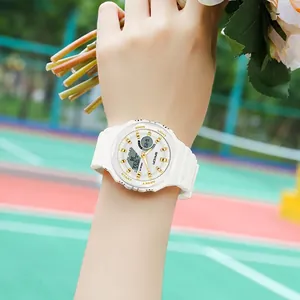 White octagonal dual-display sports watch with gold indices on a model's wrist outdoors