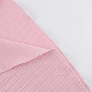 Close-up of pink knitted fabric showing soft texture and detailed ribbed weave pattern