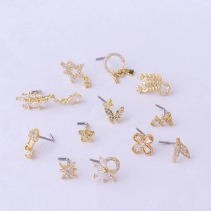 Set of 12 gold titanium steel nose studs with assorted zircon shapes on white background