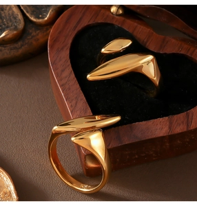 Close-up of minimalist gold-plated geometric rings inside a heart-shaped wooden gift box