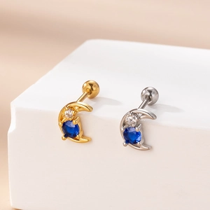 Close-up of crescent moon earrings with blue zircon in gold and silver finish
