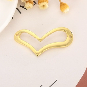 Pendentif coeur doré évidé pour création de bijoux DIY sur un fond décoratif