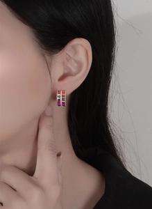 Macro detail of S925 silver C-shape earring with colorful rainbow gemstones on a model