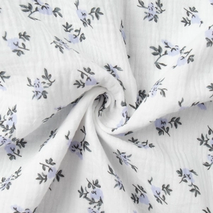 Detail of soft white cotton crepe fabric with delicate purple floral print patterns