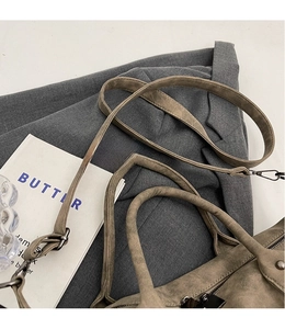 Detail of detachable shoulder strap and vintage bronze hardware on retro matte tote bag