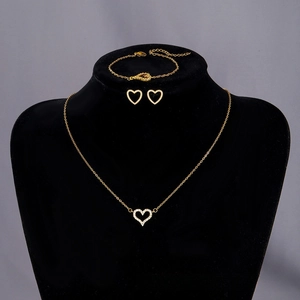 Detailed view of golden heart jewelry set with sparkling white zircon pave on black display