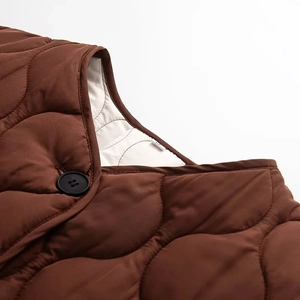 Détails de la veste matelassée en coton marron foncé avec boutons ronds noirs