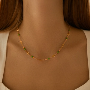 Bohemian gold chain necklace with colorful beads and clover charms on a model