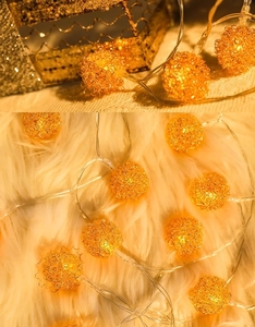 Vue macro de guirlandes lumineuses LED en fil métallique doré sur peluche blanche