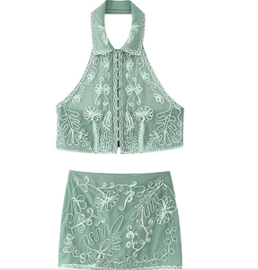 Detailed flat lay of mint green two-piece set with floral embroidery and lapel collar