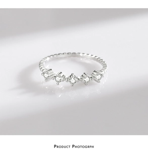 Dettaglio macro anello in argento S925 con cinque zirconi lucenti incastonati a corona