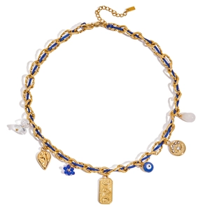 Detail of bohemian gold chain necklace with blue cord, evil eye, and sun charms