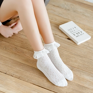 Sweet white heart-patterned lace ankle socks for women, shown on a natural wood floor