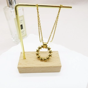 Detail of a 18K gold-plated star circle pendant on a fine cross chain necklace
