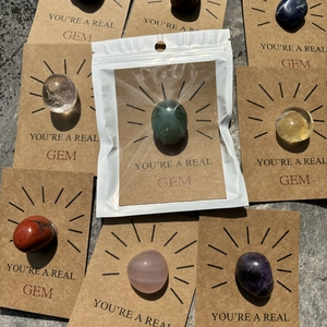 Assorted polished healing crystal stones attached to brown kraft paper greeting cards