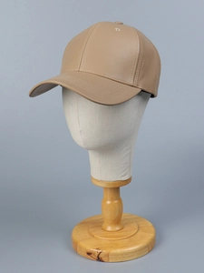 Detailed macro view of khaki PU leather baseball cap with matte texture and stitching