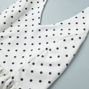 Vue détaillée du col en V sur un tissu en maille à pois blancs avec texture riche