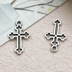 Détail de pendentifs en croix évidée argentée vintage avec extrémités en forme de trèfle
