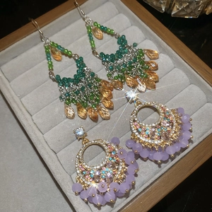Close-up of sparkling geometric crystal fringe earrings in a velvet jewelry tray