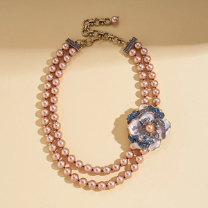 Détail de la fleur vintage avec cristaux bleus sur un collier de perles à double rang