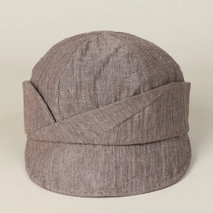 Detailed texture of brown linen newsboy cap featuring layered design and short brim