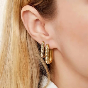 Square stainless steel 18k gold earrings with cubic zirconia shown on model's ear