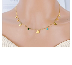 Detail of gold chain necklace with colorful zircon beads and heart-shaped charms