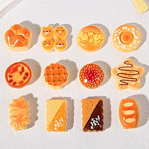 Flat lay of 12 miniature resin food charms including waffles, donuts, and burgers