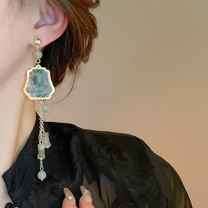 Detailed close-up of Neo-Chinese tassel earrings with bamboo resin patterns and golden chains