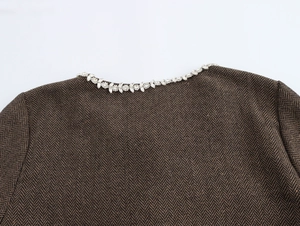 Détail d'un revers à chevrons avec bordure en strass étincelants sur veste femme