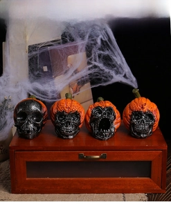 Detailed view of four resin Halloween pumpkin skulls with lifelike textures and webs