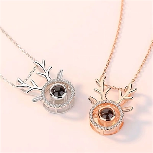 Detail of silver and rose gold elk necklaces with central projection stone and zircon inlay