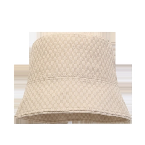 Detailed macro view of the beige sun hat featuring a breathable honeycomb texture fabric
