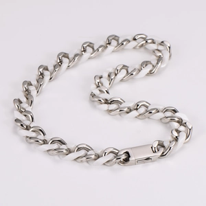 Detail of silver chain links with white ceramic segments and a secure metal clasp