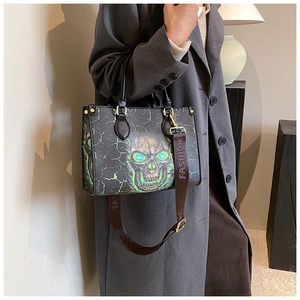 Close-up of green neon skull print on black leather bag with gold hardware detail