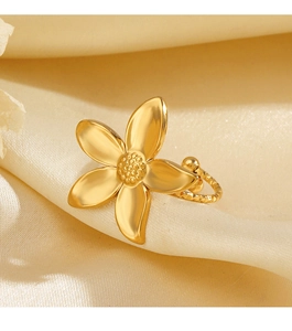 Detail of golden flower rings with petal textures on beige silk background