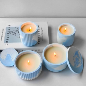 Cloud pattern scented candle set with striped ceramic jars in a cozy home setting